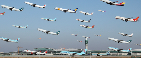 개항 예정인 인천공항 제2여객터미널 주변으로 각국 항공기들이 이착륙하는 모습을 각각의 사진으로 담아 한화면에 레이어 합성했다. 사진작가 마이크 켈리(Mike Kelly)의 작품 ‘에어포트레이츠(Airportraits)’를 참고해 촬영한 사진. /연합뉴스