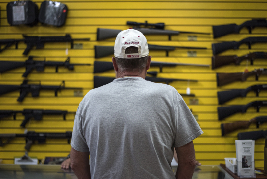 한 미국 남성이 진열된 총기를 바라보고 있다./블룸버그통신