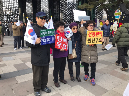 7일 서울 강남구 코엑스 앞에서 열린 ‘제8차 탄핵반대 태극기 집회’에 참여한 시민들이 박 대통령 탄핵 기각을 주장하는 피켓을 들고 있다. /이두형기자
