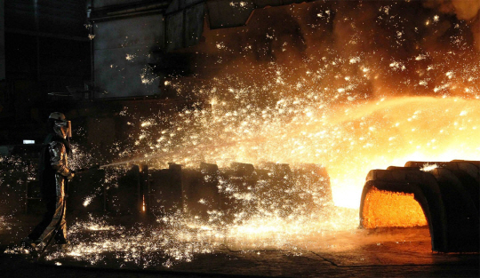 현대제철 당진제철소 직원이 고로에서 쏟아지는 뜨거운 쇳물의 열기에 맞서며 작업에 열중하고 있다.