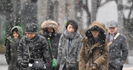 눈이 내린 13일 오전 서울 세종대로 사거리에서 시민들이 출근길을 재촉하고 있다./송은석기자
