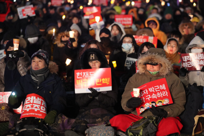 강추위가 몰아친 14일 오후 서울 광화문 광장에서 열린 제12차 범국민행동의 날 행사에서 시민들이 촛불을 들고 탄핵을 촉구하고 있다. /연합뉴스
