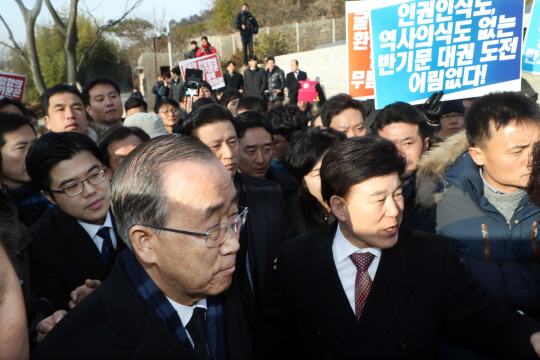 반기문 전 유엔 사무총장이 17일 경남 김해시 봉하마을의 노무현 전 대통령 묘역을 참배하려고 하자 ‘노무현을 사랑하는 사람들의 모임(노사모)’ 회원 등이 비난글을 적은 피켓을 든 채 거세게 항의하고 있다./연합뉴스