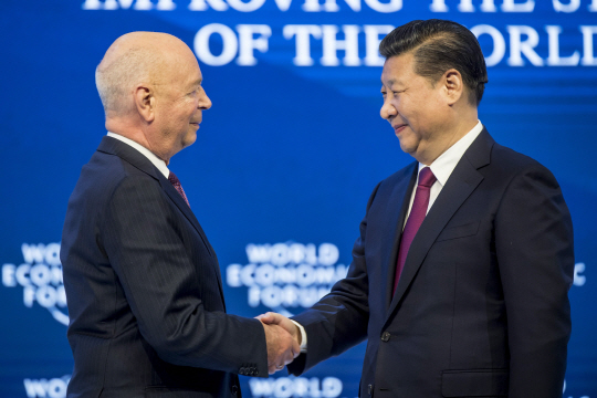 시진핑(왼쪽) 중국 국가주석이 2017 세계경제포럼(WEF·다보스포럼) 연차총회에서 클라우스 슈바프 WEF의 창업자 겸 회장와 악수하고 있다. /EPA연합뉴스