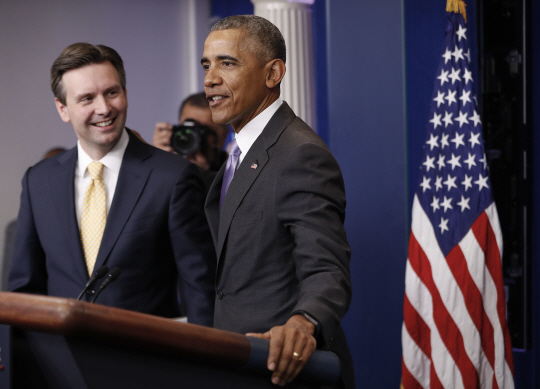 버락 오바마(오른쪽) 미국 대통령이 17일(현지시간) 백악관 브리핑룸에 등장해 조시 어니스트 백악관 대변인을 칭찬하고 있다./워싱턴DC=AP연합뉴스