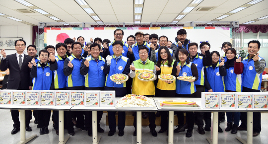 김화동(사진 앞줄 왼쪽에서 여섯번째) 한국조폐공사 사장과 권선택(〃일곱번째) 대전시장 등이 떡국떤 나눔행사를 갖고 화이팅을 외치고 있다. 사진제공=한국조폐공사