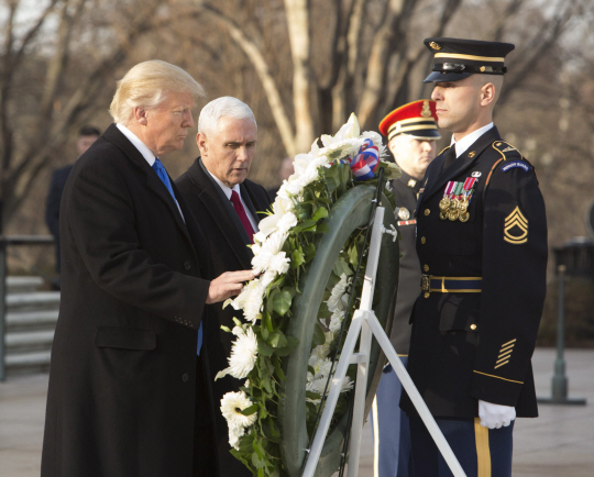 도널드 트럼프(왼쪽) 미국 대통령 당선인과 마이크 펜스(가운데) 부통령 당선인이 워싱턴DC의 알링턴국립묘지에서 헌화하고 있다./워싱턴DC=EPA연합뉴스