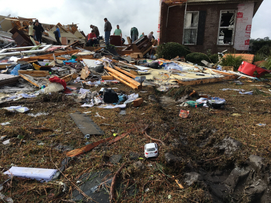 미국 조지아주 쿡 카운티의 주민들이 22일(현지시간) 토네이도로 무너진 주택 잔해를 둘러보고 있다. /쿡 카운티=AP연합뉴스