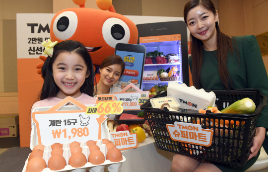 모델들이 24일 광화문 세종문화회관에서 티몬이 공식 오픈한 신선식품 판매 전용관 ‘티몬프레시’를 통해 계란 15구를 1,980원에 판매하는 행사를 알리고 있다. /이호재기자