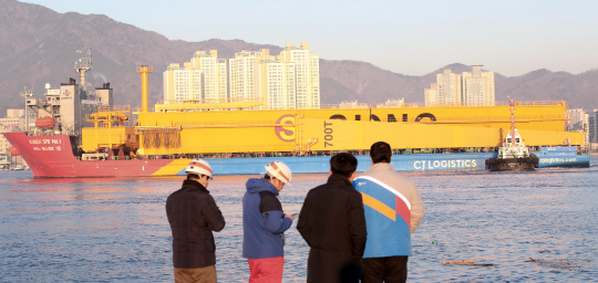 성동산업 마산조선소 골리앗 크레인이 26일 오전 경남 창원시 성산구 마산항 제4부두에서 중량물 운송 전용 선박에 실려 루마니아로 향하고 있다. 조선산업 쇠퇴로 조선소 핵심실비인 성동산업 마산조선소 크레인은 법원 경매에서 감정가 190억원이 나왔으나 국내에서 매입 의사를 밝힌 곳이 없어 루마니아의 한 조선소가 헐값에 매입했다. /창원=연합뉴스