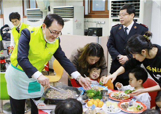 이인기(왼쪽) NH농협카드 사장과 NH농협카드봉사단원들이 25일 서울 서대문구 구세군 서울 후생원에서 아이들에게 음식을 나눠주고 있다./사진제공=NH농협카드