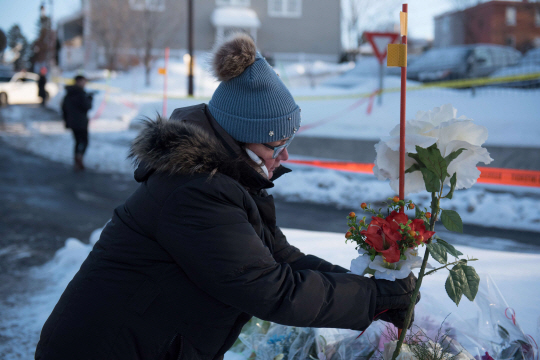 전날 총기난사 테러가 벌어진 캐나다 퀘벡주 퀘벡시 이슬람문화센터 앞에 한 여성이 희생자들을 추모하기 위해 헌화하고 있다. /퀘벡=AFP연합뉴스