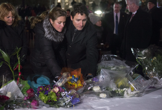 쥐스탱 트뤼도(오른쪽부터) 캐나다 총리와 부인 소피 그레고아르 여사가 30일(현지시간) 캐나다 퀘벡주 퀘벡시티에 마련된 이슬람사원 테러 희생자 추모소를 찾아 헌화하고 있다. /퀘벡시티=AP연합뉴스