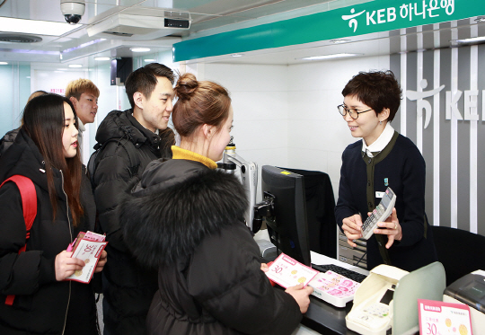 KEB하나은행 직원이 환전하려는 중국인 관광객들에게 환율을 안내하고 있다./사진제공=KEB하나은행