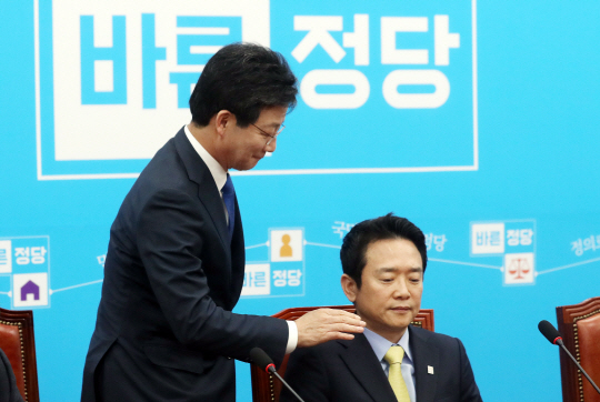 유승민 의원이 보수 후보 단일화에 대한 반대 입장을 표명한 남경필 의원의 어깨를 토닥이고 있다. /연합뉴스