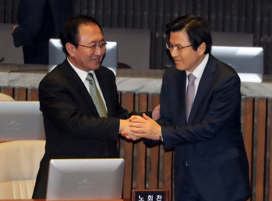 황교안 대통령 권한대행이 6일 국회 본회의장에서 열린 교섭단체 대표연설에 참석해 고교(경기고) 동기인 노회찬 정의당 원내대표와 악수하고 있다. /연합뉴스