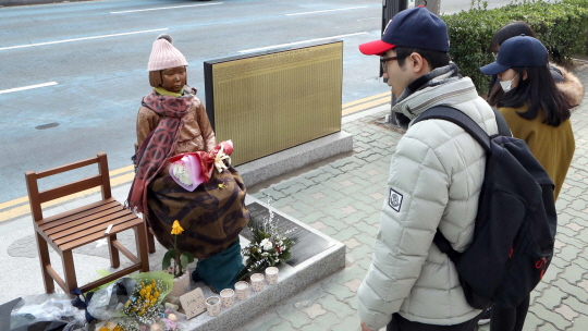 시민들이 부산 동구 초량동 주한 일본영사관 앞에 세워진 평화의 소녀상을 바라보고 있다./연합뉴스