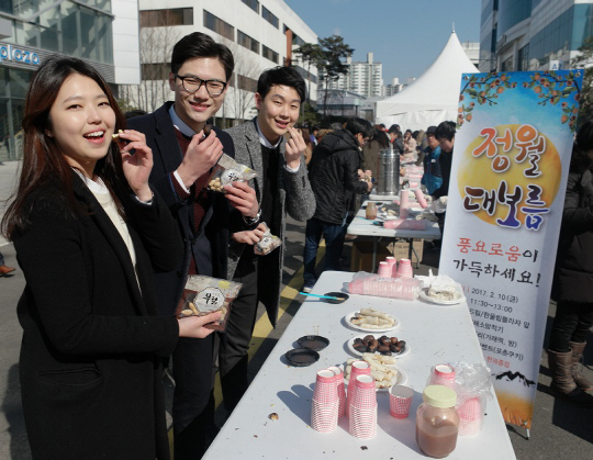 삼성전기가 11일 정월대보름을 맞아 ‘승승장구 2017 복(福) 더 주기 행사’를 지난 10일 실시한 가운데  직원들이 부럼 깨기와 군밤을 먹고 있다. /사진제공=삼성전기