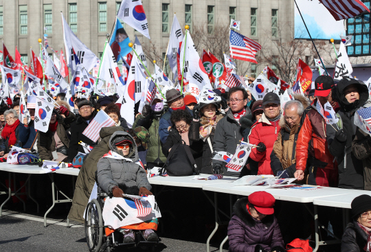 18일 서울광장 인근에서 열린 제13차 탄핵기각 총궐기 국민대회에서 참가자들이 태극기를 흔들고 있다. /연합뉴스