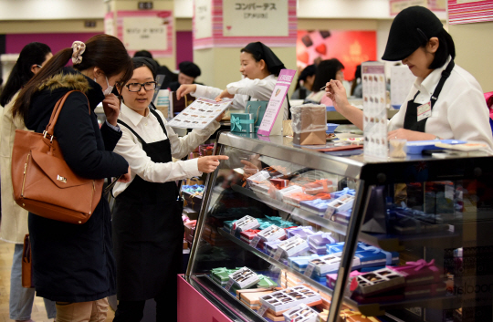 일본 한 백화점에서 직원들이 손님에게 상품을 안내하고 있다./AFP연합뉴스