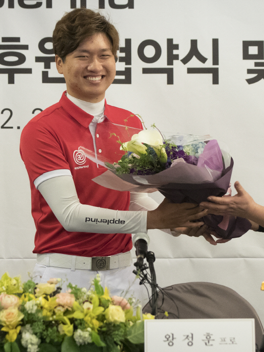 왕정훈이 23일 한국프레스센터에서 후원업체 애플라인드로부터 꽃다발을 받고 있다. /연합뉴스