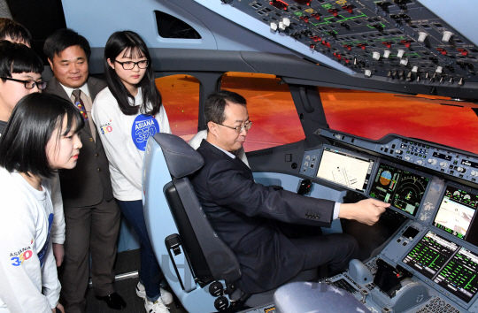 23일 서울 강서구 오쇠동 아시아나타운 운항훈련동에서 열린 A350-900 시뮬레이터 도입식에서, 참가한 김수천 사장(오른쪽)과 일산 도래울중학고 학생들이 시뮬레이터 체험을 해보고 있다.    A350-900 시뮬레이터는 실제 항공기 조종석과 동일한 형태의 시설에서 비행훈련 외에도 취항지 중 특이항공 이착륙, 화재상황에 대한 훈련 등이 가능하다./이호재기자