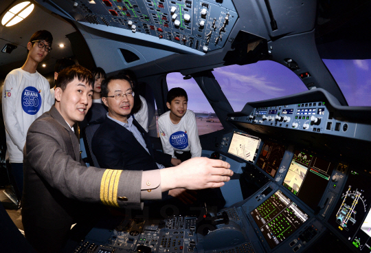 23일 서울 강서구 오쇠동 아시아나타운 운항훈련동에서 열린 A350-900 시뮬레이터 도입식에서, 참가한 김수천 사장(앞줄 왼쪽 두번째)과 일산 도래울중학고 학생들이 시뮬레이터 체험을 해보고 있다.    A350-900 시뮬레이터는 실제 항공기 조종석과 동일한 형태의 시설에서 비행훈련 외에도 취항지 중 특이항공 이착륙, 화재상황에 대한 훈련 등이 가능하다./이호재기자