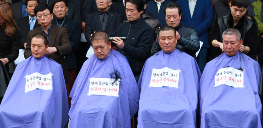 지난 20일 오전 울산시 동구청 앞에서 권명호(왼쪽) 동구청장과 시·구의원들이 현대중공업 분사 반대 기자회견을 앞두고 삭발식을 하고 있다.  /연합뉴스