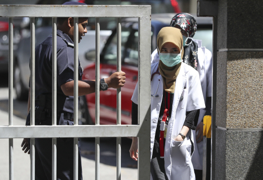 지난 16일 피살된 김정남의 사인을 분석하기 위해 부검이 진행됐던 말레이시아 쿠알라룸푸르 병원에서 과학수사요원들이 문을 나서고 있다.     /쿠알라룸푸르=AP연합뉴스