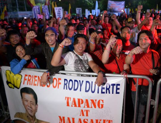 필리핀 민주화 혁명인 ‘피플파워’ 혁명 31주기인 25일 로드리고 두테르테 필리핀 대통령 지지자들이 수도 마닐라에서 주먹을 들어올리며 두테르테 대통령의 정책에 찬성한다는 의사를 보이고 있다.  /마닐라=AFP연합뉴스