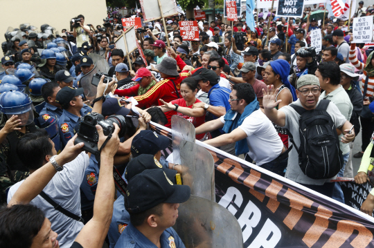 로드리고 두테르테 필리핀 대통령에 반대하는 시민들이 25일 퀘존시티에서 경찰과 충돌하고 있다. 이 시민들은 두테르테 대통령의 마약 소탕작전·야권 정치인 구속 등에 항의했다.  /퀘존시티=EPA연합뉴스