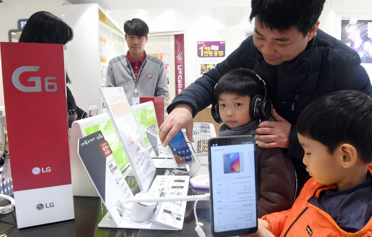 LG전자가 전략 스마트폰 ‘LG G6’ 출시를 앞두고 2일부터 예약 판매를 시작했다. 서울시청역 인근 판매점에서 한 가족이 G6를 작동해보고 있다. /이호재기자