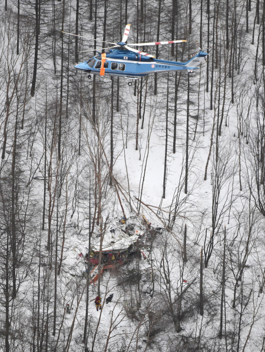 일본 나가노현의 한 산에 추락한 소방헬기 위로 다른 헬기 한 대가 5일 구조 작업을 벌이고 있다. /마쓰모토=교도연합뉴스