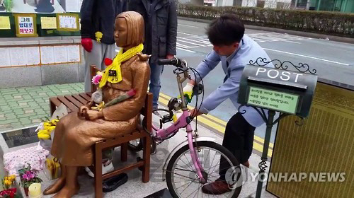 부산겨레하나 회원이 부산 일본 대사관 앞 ‘평화의 소녀상’에 묶인 자물쇠를 절단기로 자르고 있다. /연합뉴스