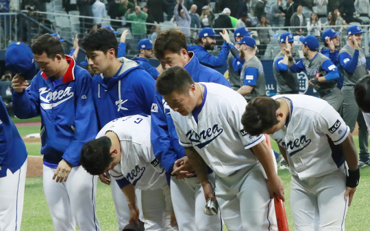 6일 서울 고척스카이돔에서 열린 ‘2017 월드베이스볼클래식(WBC)’ 개막전에서 이스라엘과의 연장 승부 끝에 2대1로 패배한 한국 대표팀 선수들이 관중들에게 고개 숙여 인사하고 있다. 뒤로는 이스라엘 선수들이 손바닥을 부딪치며 승리를 자축하고 있다. /연합뉴스