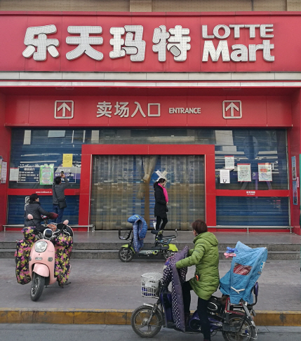 6일(현지시간) 중국 장쑤성 화이안시 사람들이 정부 규제로 갑자기 문을 닫은 롯데마트 앞을 살펴보고 있다. /화이안=EPA연합뉴스