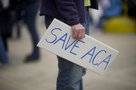 미국 펜실베이니아주 필라델피아에서 한 시민이 ‘오바마케어(ACA)를 구하라’는 문구가 적힌 푯말을 들고 있다./필라델피아=AFP연합뉴스