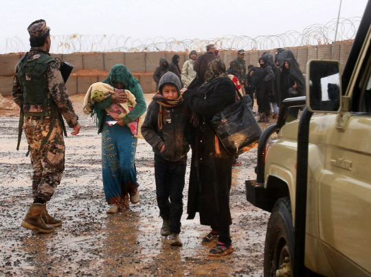 병을 앓고 있는 시리아 난민들이 지난 1일(현지시간) 요르단과 시리아 국경지역에 있는 럭반캠프에서 병원으로 이동하기 위해 차량으로 이동하고 있다.      /럭반=AFP연합뉴스