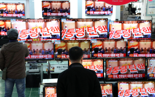 10일 오전 서울 용산구 전자랜드에서 시민들이 TV로 헌법재판소의 박근혜 대통령 파면 선고를 보고 있다.