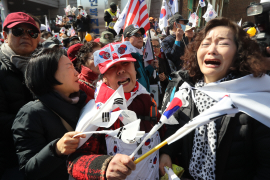서울 종로구 수운회관 앞에서 탄핵 반대 집회를 하던 시민들이 오열하고 있다.
