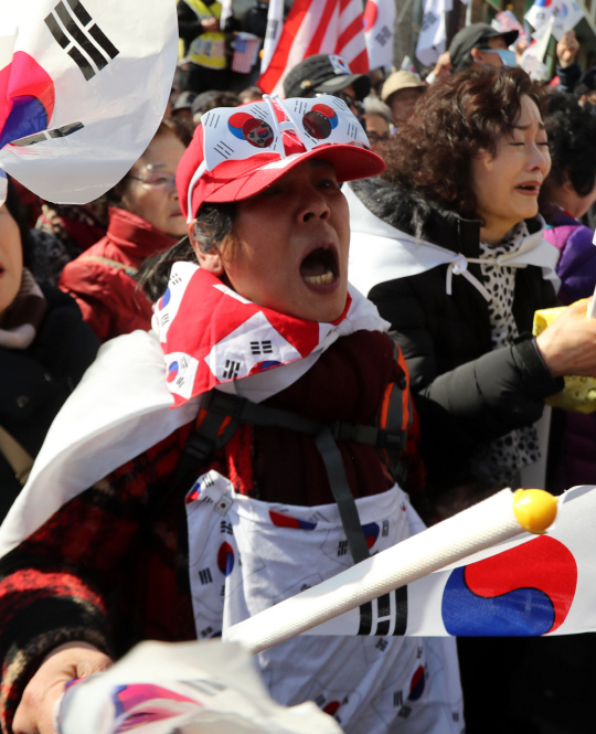 10일 헌재가 대통령 탄핵 인용 발표를 하자 종로구 수운회관 앞에서 탄핵 반대 집회를 하던 시민들이 태극기를 들고 소리를 지르고 있다.