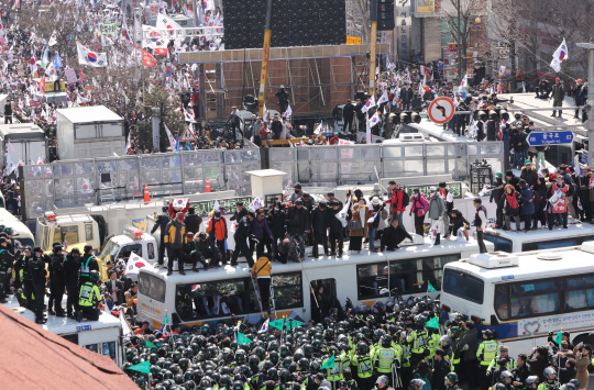 대통령 탄핵에 반대하던 시민들이 경찰차벽 위로 올라 대치하고 있다.