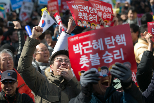 박근혜 대통령 탄핵안이 인용된 10일 서울 종로경찰서 앞에서 열린 박근혜 퇴진 비상국민행동의 집회에 참가한 시민들이 환호하고 있다./이호재기자.