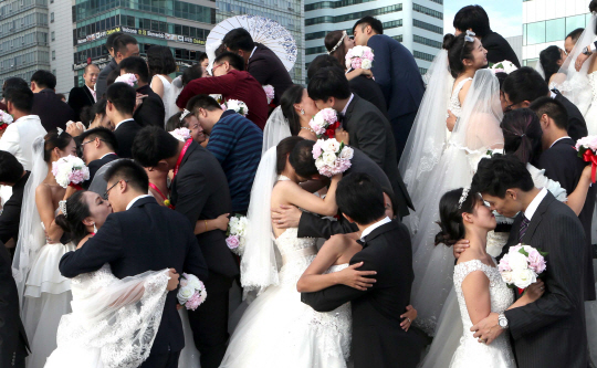 중국인 예비신혼부부 78쌍이 26일 오후 부산 해운대해수욕장에서 결혼식을 하면서 키스를 하고 있다. /부산=연합뉴스