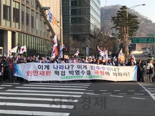친박단체들로 구성된 집회 참가자들이 11일 서울 중구 남대문시장 근처에서 특검을 비판하는 플랜카드를 들고 행진하고 있다./이두형 기자