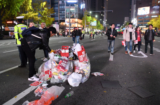 지난해 11월 12일 서울 광화문광장에서 열린 3차 촛불집회가 끝나고 시민들이 쓰레기를 치우고 있다. /권욱기자