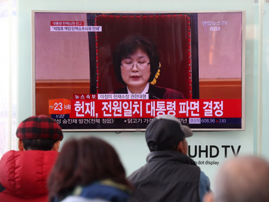 시민들이 10일 오전 울산역 대합실에 설치된 TV 중계 화면을 통해 박근혜 전 대통령 파면 소식을 듣고 있다. /연합뉴스