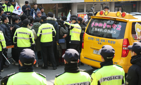 16일 오후 박근혜 전 대통령 지지자들이 집회를 하고 있는 서울 강남구 삼성동 박근혜 전 대통령 자택 앞으로 인근 어린이집 차량이 지나고 있다./연합뉴스