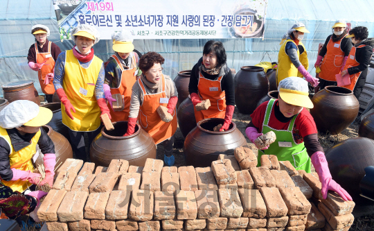 17일 서초구청 주최로 서초구 대원농장에서 열린 사랑 담아 된장 간장 만들어요 행사에 참석한 자원봉사자들이 항아리에 메주를 넣고 있다. 이 행사는 주민과 기업 봉사자 60여명이 참여, 10월경 저속득 독거 어르신 및 소년소녀가장 등 300여세대에 전달 예정이다./이호재기자. s020792@sedaily.com