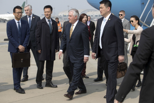 렉스 틸러슨 미국 국무장관(가운데)이 18일(현지시간) 중국 베이징 국제공항에 도착, 관계자들의 안내를 받고 있다.  /베이징 AP=연합뉴스